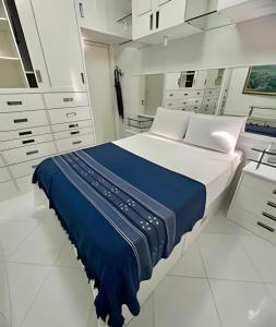 um grande quarto branco com uma cama e armários brancos em UNU 1505 - Corredor da Vitória: Vista mar, Wi-fi + em Salvador