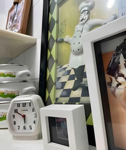 um relógio e uma imagem em uma mesa ao lado de uma geladeira em UNU 1505 - Corredor da Vitória: Vista mar, Wi-fi + em Salvador