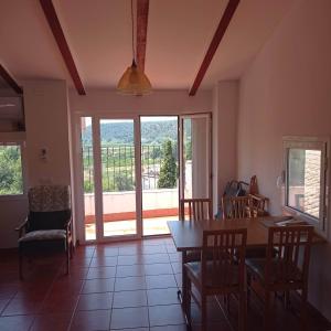 a living room with a table and chairs and windows at Casa Ermita in Benifallet