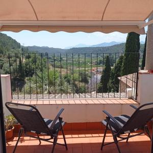 a balcony with two chairs and a view of the mountains at Casa Ermita in Benifallet +18 photos