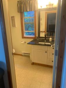 a bathroom with a sink and a mirror at West facing Waterfront Retreat with private beach, dock access & private buoy in Blind Bay +11 photos