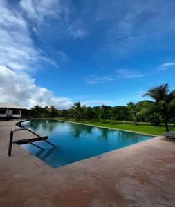 a swimming pool with a bench in front of it at UNU 204 Studio Praia do Forte: Wifi, Piscina e + in Mata de Sao Joao