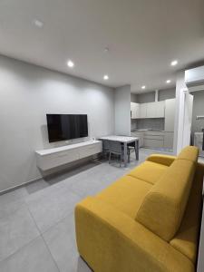 sala de estar con sofá amarillo y TV en Vulcano Apartments, en Cirò Marina 14 fotos más
