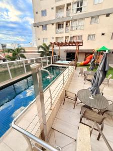 un balcón con piscina y sillas y un edificio en Exclusivity in Itajaí Port with Wi-Fi and Jacuzzi, en Itajaí