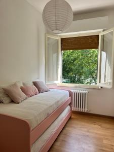 a bedroom with a bed and a large window at Casa Frasassi in Falcioni