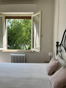 a bedroom with a large bed with a window at Casa Frasassi in Falcioni