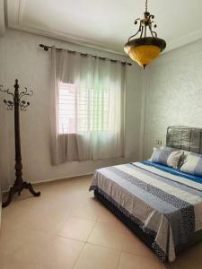 a bedroom with a bed and a chandelier at Fès Medina Escape Apartment in Fez