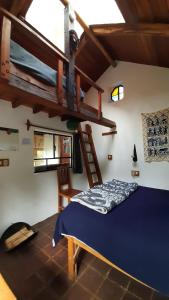 a bedroom with a bed and a wooden ladder at The Black Sheep Inn in Huamboya