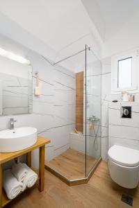 a white bathroom with a sink and a toilet at Pelagos Home, Liatiko Suite in Kalamaki Heraklion