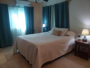 una camera da letto con un grande letto con tende blu di West End Room Shuttle Free a West End