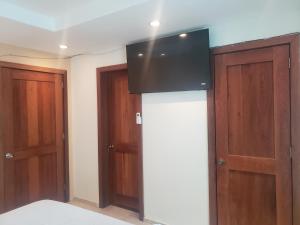 una stanza con due porte e una televisione sul muro di West End Room Shuttle Free a West End