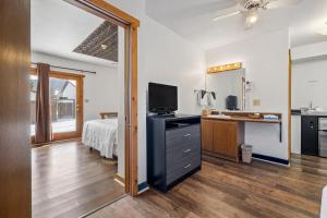 a bedroom with a bed and a flat screen tv at The Sturgis Motel in Sturgis