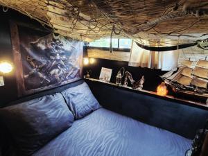 a bed in a room with a boat on the wall at L'évasion - Pairi Daiza - Insolite in Chièvres