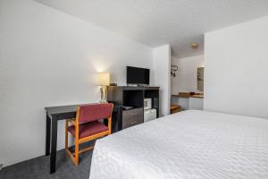 a bedroom with a bed and a desk with a computer at The Sturgis Motel in Sturgis