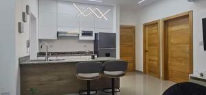 una cucina con due sgabelli e un lavandino di Yuniel RT a Santo Domingo
