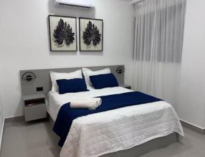 una camera da letto con un letto grande con cuscini blu di Yuniel RT a Santo Domingo