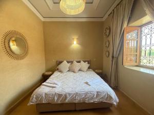 a bedroom with a bed and a window and a mirror at Villa Lina in Marrakesh