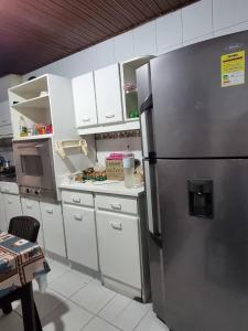 a kitchen with a stainless steel refrigerator and white cabinets at Hostal Casalé Usaquén Embajada de Mexico in Bogotá