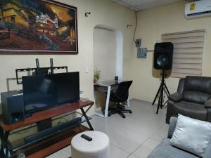 a living room with a tv and a couch and a table at Beautiful and comfortable house in Sonsonate