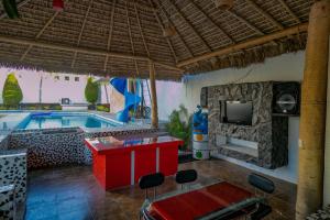 a living room with a pool and a red table and chairs at Hotel Mi Bendición in Los Limones