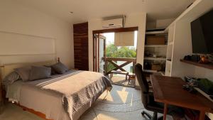 a bedroom with a bed and a desk and a window at Casa Aurea Club de Golf Santa Fe in Xochitepec