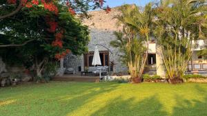 a yard with a house with a umbrella and trees at Casa Aurea Club de Golf Santa Fe in Xochitepec