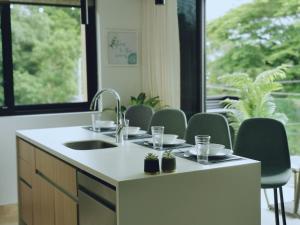 a kitchen with a sink and chairs and a window at Our Paradise - Jaco Apartment in Jacó