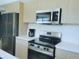 a kitchen with a stove and a microwave at Our Paradise - Jaco Apartment in Jacó