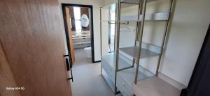 a bathroom with a glass cabinet and a mirror at Casa Gaia GuestHouse in Ilhabela