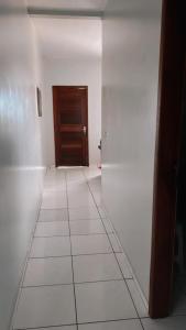 a hallway with a door and a white tile floor at Apartamento mobiliado in Belém +1 photo