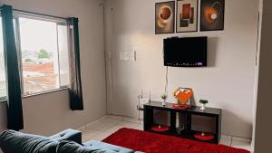 a living room with a couch and a flat screen tv at Apartamento mobiliado in Belém