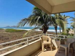 a balcony with chairs and a view of the beach at Beautiful beachfront space and pool in Mazatlán