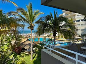 a view of a resort with a pool and palm trees at Beautiful beachfront space and pool in Mazatlán