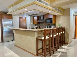 a kitchen with a island with bar stools at Beautiful beachfront space and pool in Mazatlán