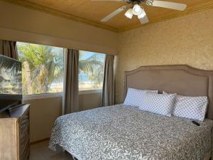 a bedroom with a bed and a ceiling fan at Beautiful beachfront space and pool in Mazatlán +31 photos