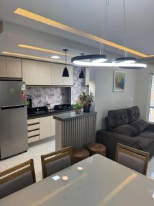 a kitchen and living room with a table and a couch at Belíssimo Apto a 2 km da Litorânea in São Luís