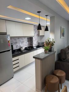 a kitchen with white cabinets and a bar in a room at Belíssimo Apto a 2 km da Litorânea in São Luís