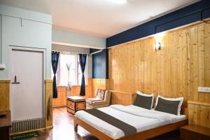 拉冲Hotel O Kaizen Residency的一间卧室，里面有一张床、一把椅子和一扇窗户