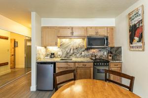 eine Küche mit Holzschränken und einem Holztisch in der Unterkunft 233 Bldg C condo in Truckee