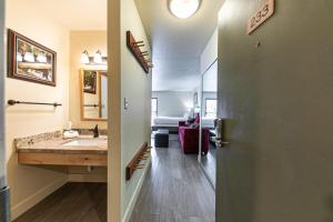 einen Flur mit einem Bad mit einem Waschbecken und einer Tür in der Unterkunft 233 Bldg C condo in Truckee