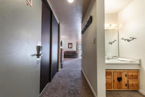 a hallway of a bathroom with a sink and a mirror at 224 Bldg B condo in Truckee