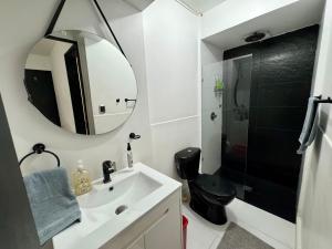 Un baño con lavabo, espejo y ducha. en EasyHouse, en Medellín