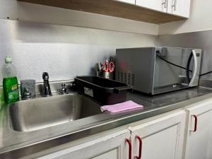 Una encimera de cocina con fregadero y microondas. en EasyHouse, en Medellín 30 fotos más