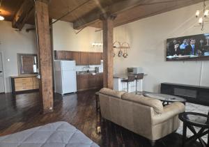 een woonkamer met een bank en een keuken bij Motown Riverfront Studio Loft in Detroit