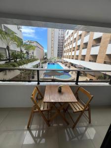 a table and chairs on a balcony with a pool at Flat a 50m da beira-mar do Cabo Branco - Gold Flat 121 in João Pessoa