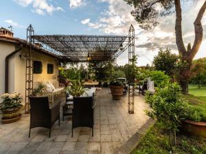 a patio with a pergola and tables and chairs at Farmhouse in Pescia with Pool and Gardens in Pescia