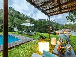 a patio with a table and chairs next to a pool at Villa in Lucca with Private Pool in San Macario In Piano