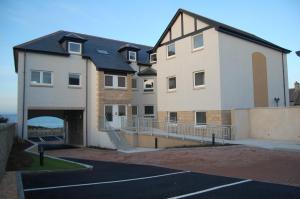 a building with a parking lot in front of it at Lossiemouth Haven in Lossiemouth