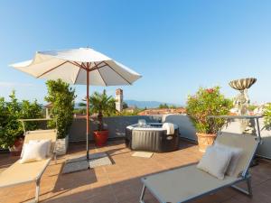 a patio with an umbrella and chairs and a heater at Apartment in Lucca near Historic Center in Lucca