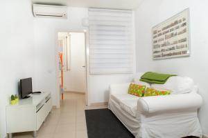 uma sala de estar branca com um sofá branco e uma televisão em Apartament Conde Güell em Barcelona